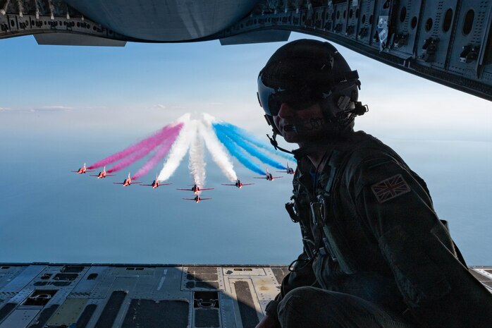 Royal Air Force Flight Lieutenant Sam Froggatt, a pilot with the C-17 East Coast Demo Team, poses for a photo with the Royal Air Force Red Arrows over the coast in Boston, Massachusetts, July 11th, 2026. Froggatt helped to facilitate the historic flyover, acting as a liaison between the two demonstration teams. (U.S. Air Force photo by Staff Sgt. Zachary Wright)