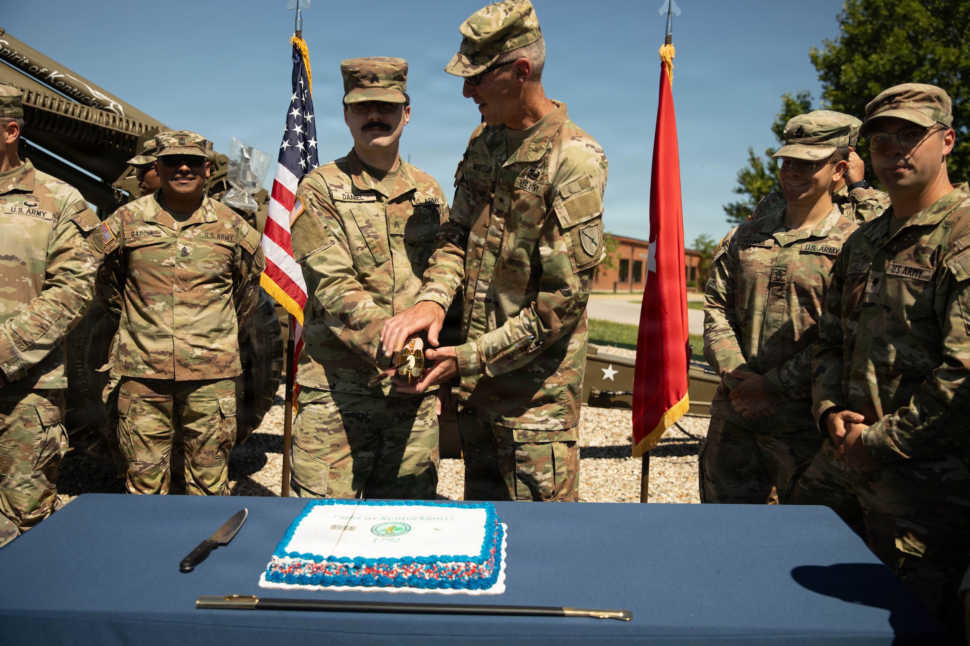 U.S. Army Sgt. Colin Daniel, the youngest Soldier in attendance, and Brig. Gen. Brian Wertzler participate in a ceremonial cake-cutting during a birthday celebration at Boone National Guard Center in Frankfort, June 24. The tradition symbolizes the passing of knowledge, experience and service from one generation of Guardsmen to the next while commemorating the Kentucky National Guard's history of service to the Commonwealth and nation. (U.S. Army National Guard photo by Milt Spalding)