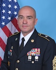Command Sergeant Major James Perrault was born in Stuttgart, Germany. He enlisted in the Massachusetts Army National Guard on June 26, 1993, and completed Basic Training at Fort Jackson, South Carolina. He then went on to Advanced Individual Training at Fort Lee, Virginia. He began his career as a 77F Petroleum Supply Specialist, joining the 181st Infantry Company, Worcester, MA. Later in CSM Perrault’s career he became an 88M attending the Motor Transporter Course assigned to the 1166th Transportation Company in Ware, MA He served in numerous roles from wheeled vehicle driver to Squad Leader. 

He was deployed to Ft. Bragg, North Carolina in 2003 in support of Operation Enduring Freedom and then again in 2010 to Kuwait with 1166th HET Company as a platoon Sergeant and Acting First Sergeant in support of Operation Iraqi Freedom and Operation New Dawn.

His previous assignments include: 
Senior Truckmaster, 1060th Transportation Company in Framingham, MA.
Senior Truckmaster, 1166th Transportation Company in Worcester, MA 
First Sergeant,1166th Transportation Company.
Command Sergeant Major, 164th Transportation Battalion. 
Operations Sergeant Major, 151 Regional Support Group.
Command Sergeant Major, 151 Regional Support Group.

Command Sergeant Major Perrault’s military awards and decorations include the Legion of Merit, Bronze Star Medal, Meritorious Service Medal with one oak leaf cluster, Army Commendation Medal, Air Force Commendation Medal, Army Achievement Medal with Four Oak Leaf Clusters, Iraq Campaign Medal with 2 Campaign Stars, Noncommissioned Professional Development Ribbon with Numeral 5. CSM Perrault is a graduate of the Sergeants Major Academy, Class 47.

Command Sergeant Major Perrault lives in Ashburnham, MA with his wife Nicole, children Travis & Jillian and their beloved boxer Cora.