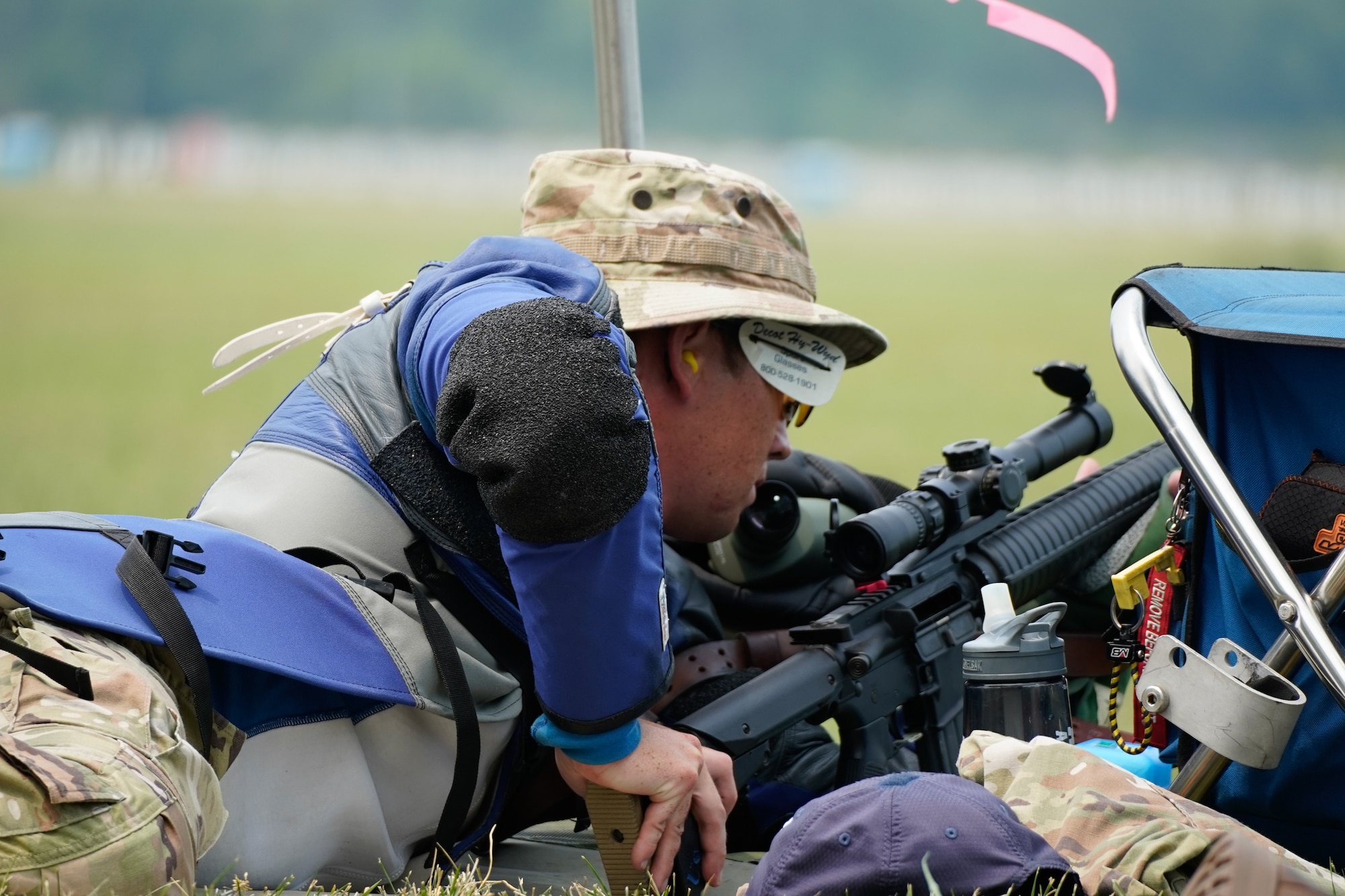 Uniformed member adjusts rifle stock while lying down.
