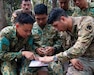 U.S. Army and Royal Brunei Land Force (RBLF) Soldiers work together to plot a grid coordinate on a map during jungle land navigation training at Tutong Camp, Brunei Darussalam, Aug. 12, 2026. Oklahoma Army National Guard Soldiers with 1st Squadron, 180th Regiment, 45th Infantry Brigade Combat Team worked alongside 3rd Platoon, Alpha Company, 2nd Battalion, RBLF to develop land navigation skills in a jungle environment as part of Exercise Pahlawan Warrior 26. Exercise Pahlawan Warrior is a biennial bilateral exercise between the U.S. Army Pacific and the RBLF, designed to enhance readiness, interoperability, and strengthen bilateral defense cooperation. (Oklahoma National Guard photo by Sgt. Danielle Rayon)