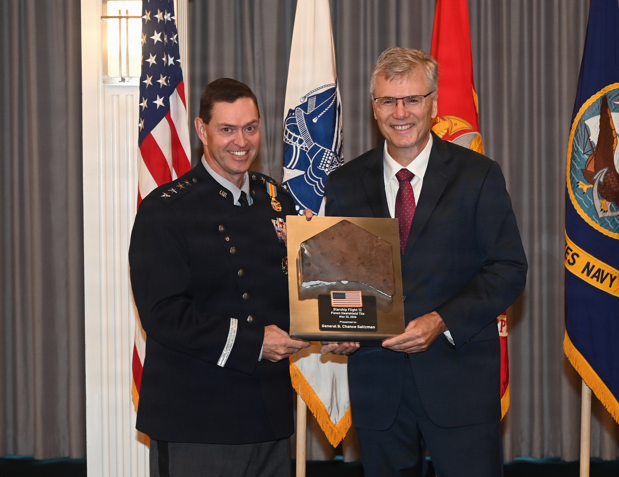 Secretary of the Air Force Troy Meink presents a gift to Chief of Space Operations Gen. Chance Saltzman during his retirement ceremony, Joint Base Anacostia-Bolling, Washington D.C., Aug. 13, 2026. Saltzman was the second Chief of Space Operations and originally commissioned into the Air Force in 1991. (U.S. Air Force photo by Andy Morataya)