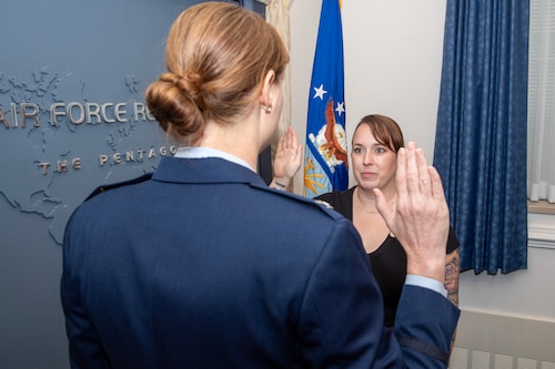 Master Sgt. Jessica Meinert takes the oath of re-enlistment during a ceremony in the Pentagon Aug. 14.