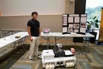 FREDERICKSBURG, Va. – Eighteen-year-old Joseph Shanklin, West Moreland High School graduate, participated in the NSWCDD Science and Engineering Apprenticeship Program with a team that created software for an all-terrain autonomous rover with object detection and manual override capability. Shanklin stands with the project at the NSWCDD Poster Session July 30 where they showcased their work at the University of Mary Washington’s Dahlgren Campus. (Jennifer Erickson/NSWCDD Photo)