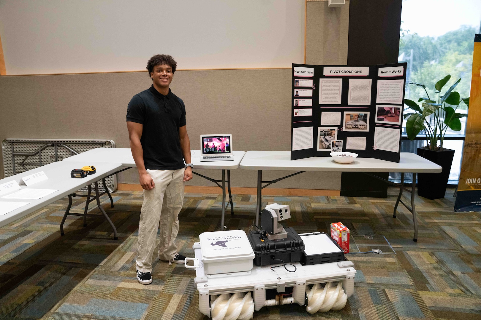 FREDERICKSBURG, Va. – Eighteen-year-old Joseph Shanklin, West Moreland High School graduate, participated in the NSWCDD Science and Engineering Apprenticeship Program with a team that created software for an all-terrain autonomous rover with object detection and manual override capability. Shanklin stands with the project at the NSWCDD Poster Session July 30 where they showcased their work at the University of Mary Washington’s Dahlgren Campus. (Jennifer Erickson/NSWCDD Photo)