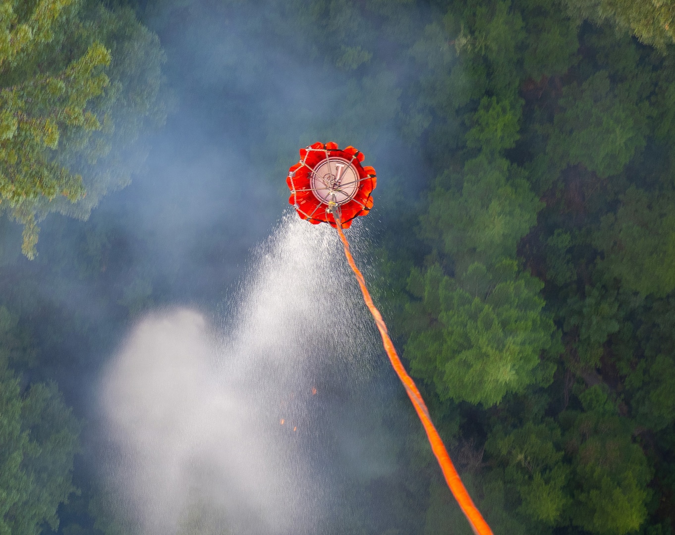 A water bucket releases from an Oregon Army National Guard HH-60M Black Hawk helicopter during a spot drop on a fire that had spread into unburned terrain along the Hagen Fire in Umatilla County, Oregon, Aug. 10, 2026.