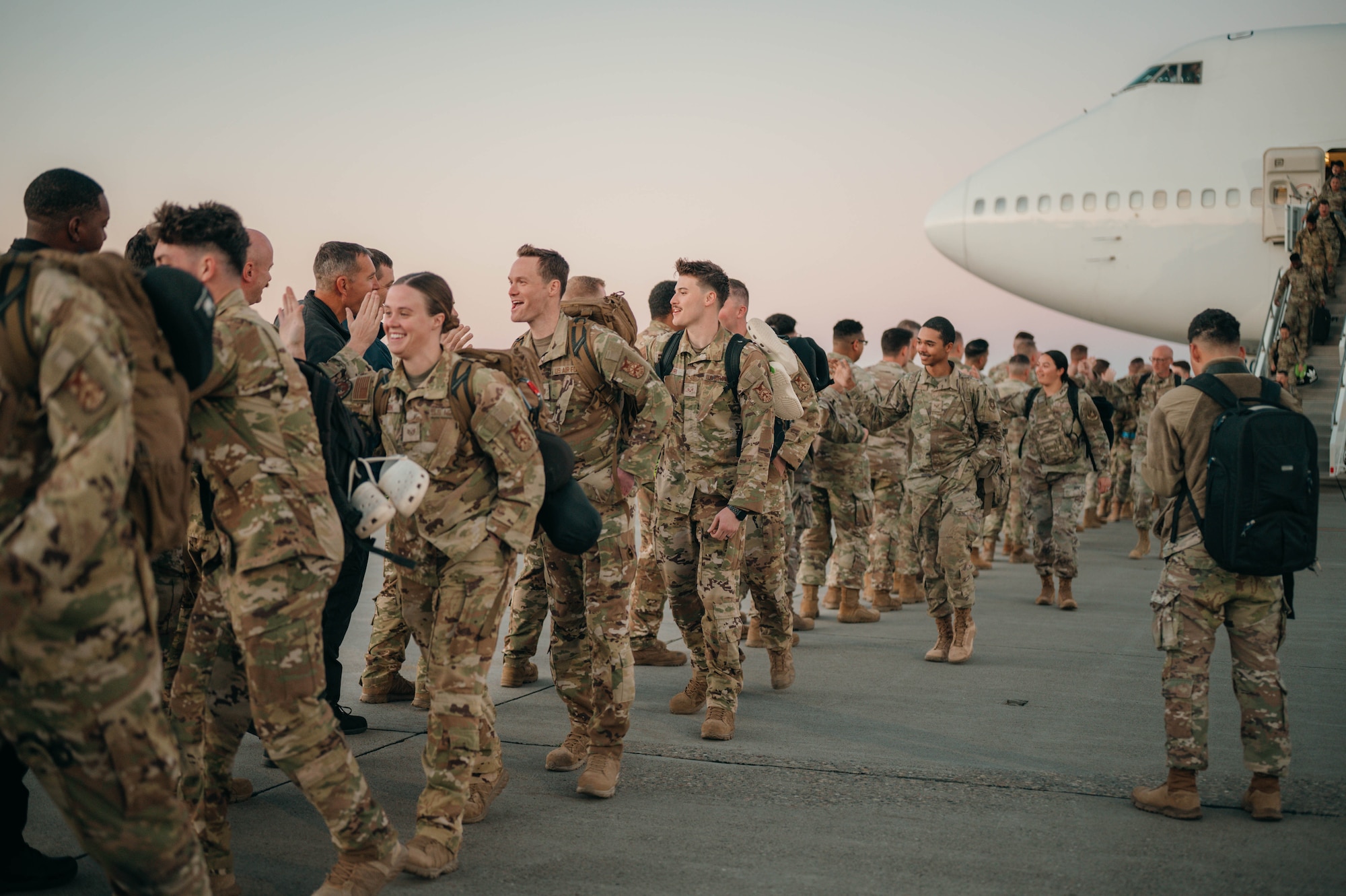 Airmen step off a plane coming home from deployment