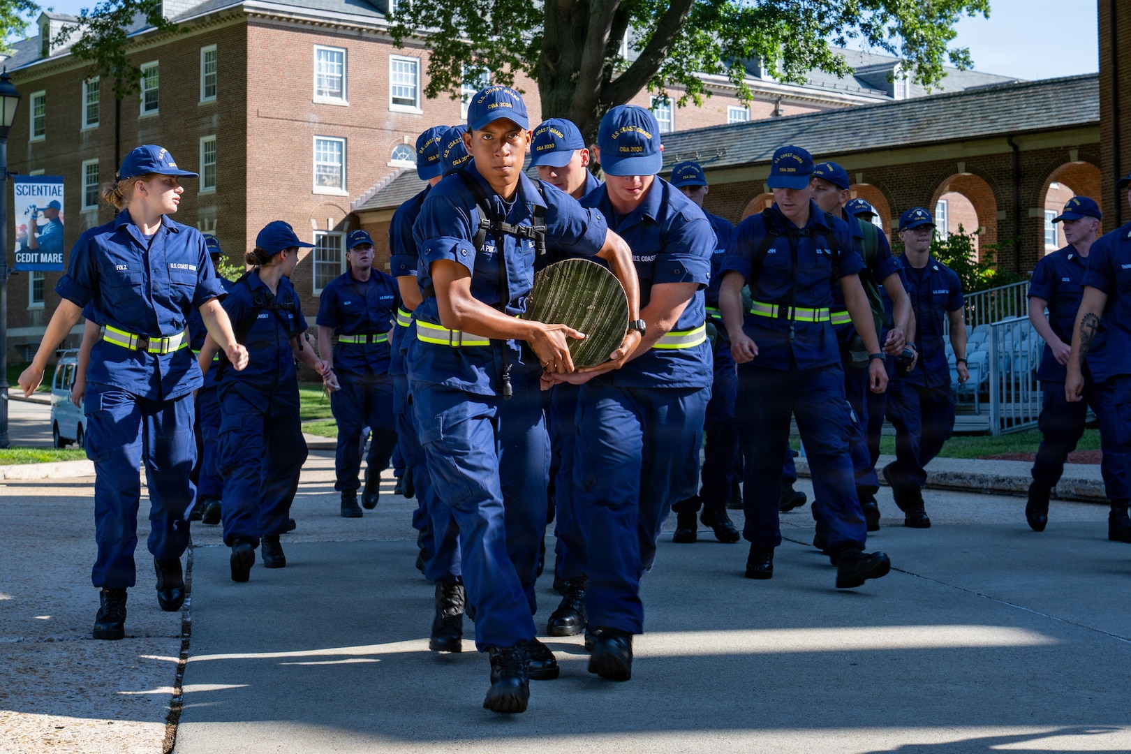 U.S. Coast Guard cadets work together to carry a log during sea trials at the Academy in New London, Conn., Aug. 14, 2026. The daylong event tests swabs physical endurance, mental resilience and teamwork as they complete their summer training program. (U.S. Coast Guard photo by Petty Officer 3rd Class Roxanna Jacobo Cruz)