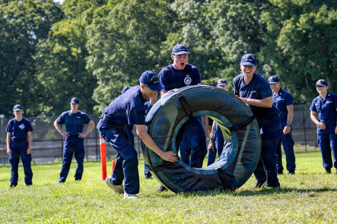 U.S. Coast Guard Cadets flip a tire during sea trials at the Academy, New London, Conn., Aug. 14, 2026. The daylong event tests swabs physical endurance, mental resilience and teamwork as they complete their summer training program.(U.S. Coast Guard photo by Petty Officer 3rd Class Roxanna Jacobo Cruz)