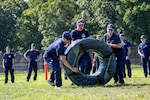 U.S. Coast Guard Cadets flip a tire during sea trials at the Academy, New London, Conn., Aug. 14, 2026. The daylong event tests swabs physical endurance, mental resilience and teamwork as they complete their summer training program.(U.S. Coast Guard photo by Petty Officer 3rd Class Roxanna Jacobo Cruz)
