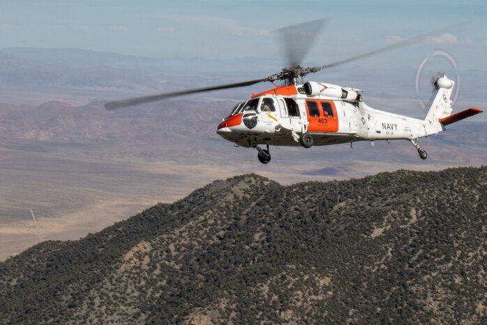 An Air Test and Evaluation Squadron (VX) 31 MH-60S Seahawk flies over mountainous terrain during search and rescue training at Naval Air Weapons Station China Lake, California, June 15, 2026. VX-31's search and rescue crews train across desert and mountain terrain to sustain readiness for the squadron's developmental flight test mission. (U.S. Navy photo by Michael L. Smith)