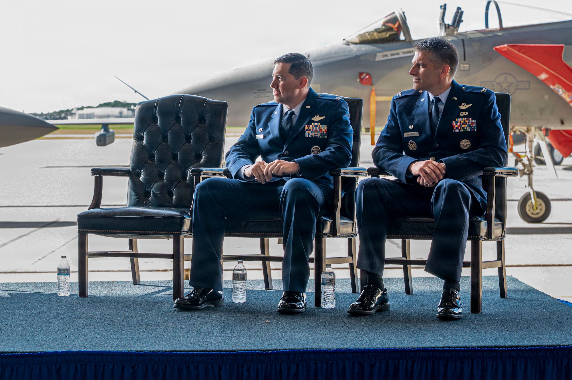 U.S. Air Force Col. David Deptula, left, outbound 18th Operations Group commander, and U.S. Air Force Col. Jeffery Peterson, right, inbound 18th OG commander, listen to remarks