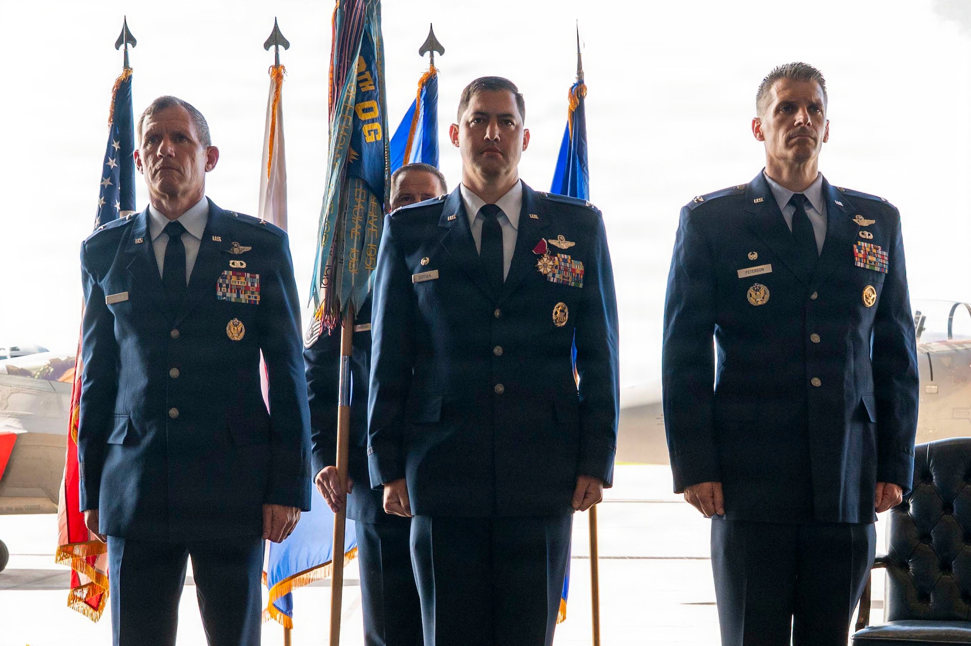 U.S. Air Force Brig. Gen. John Gallemore, left, 18th Wing commander, U.S. Air Force Col. David Deptula, center, outbound 18th Operations Group commander, and U.S. Air Force Col. Jeffery  Peterson, inbound 18th OG commander, stand at attention