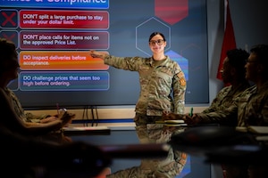 A woman in uniform briefs a class.