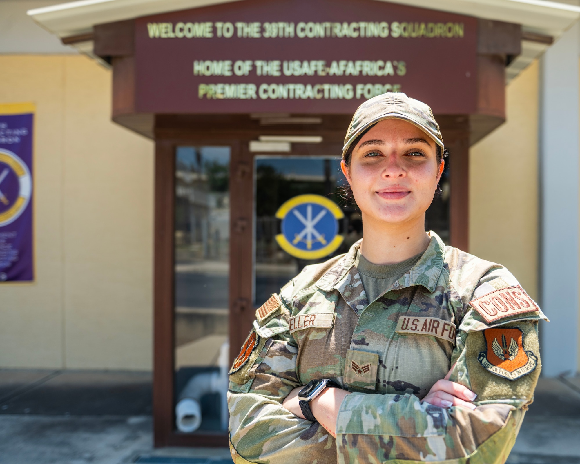 A woman in uniform stands in front of a building.