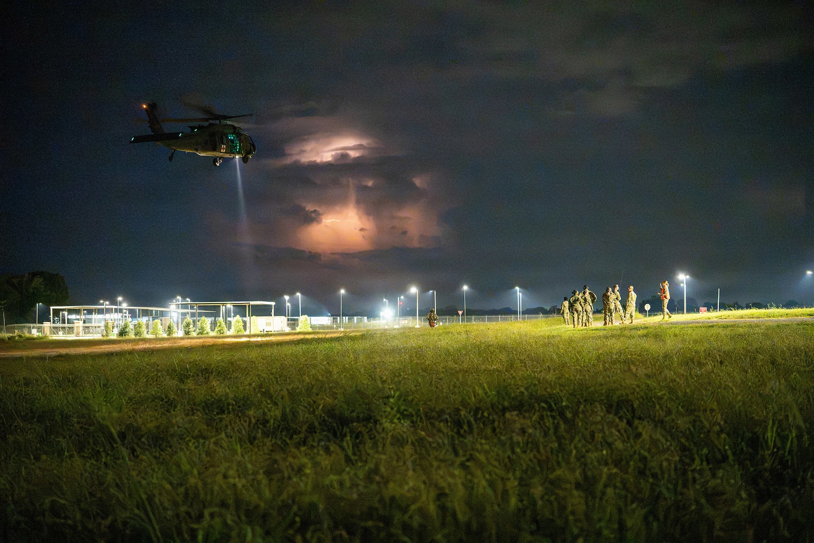 An Alabama Army National Guard UH-60 Black Hawk helicopter conducts nighttime operations during Operation Tuskegee Thunder at Dannelly Field, Alabama, Aug. 13, 2026, as lightning illuminates a storm in the distance.