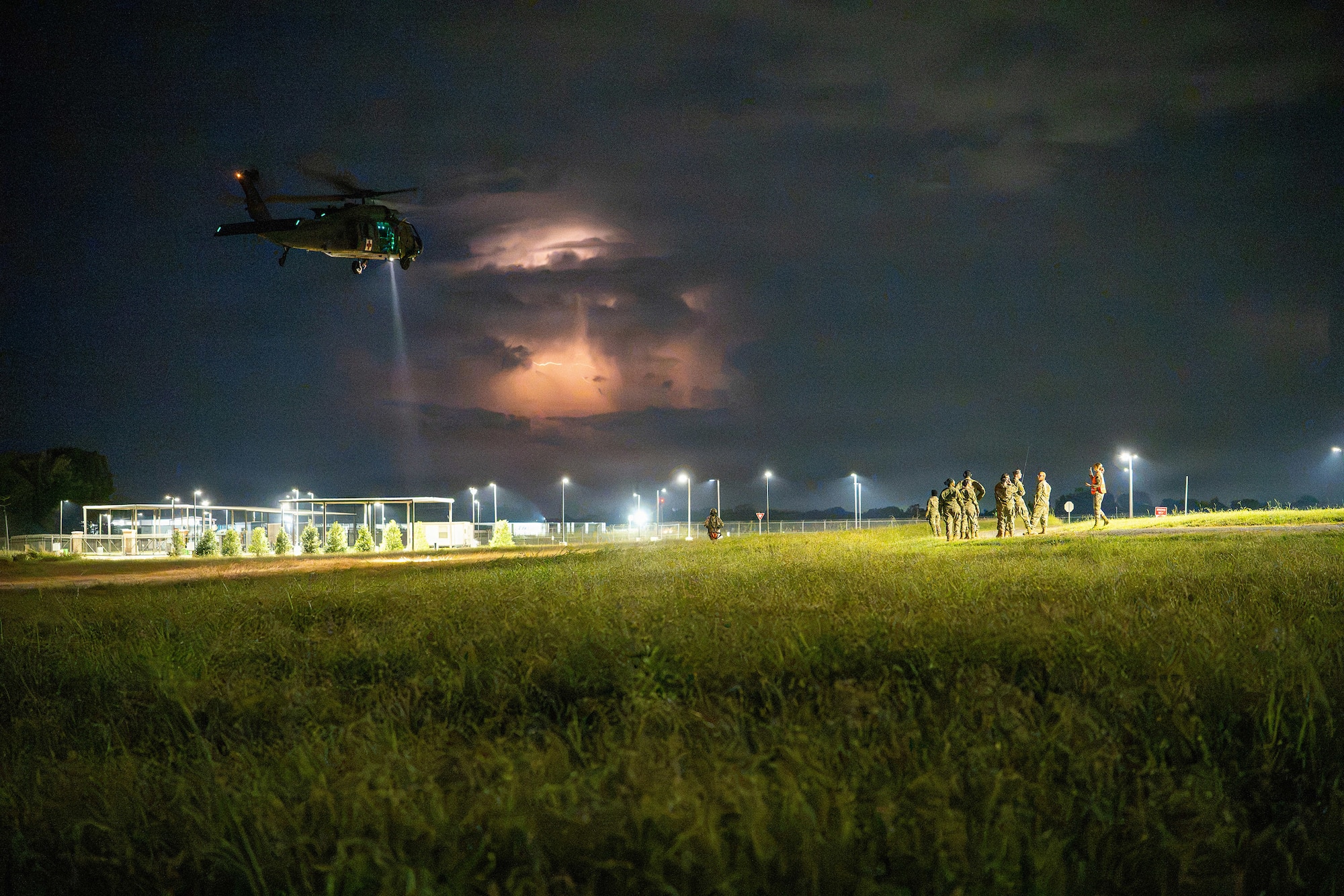 An Alabama Army National Guard UH-60 Black Hawk helicopter conducts nighttime operations during Operation Tuskegee Thunder at Dannelly Field, Alabama, Aug. 13, 2026, as lightning illuminates a storm in the distance.