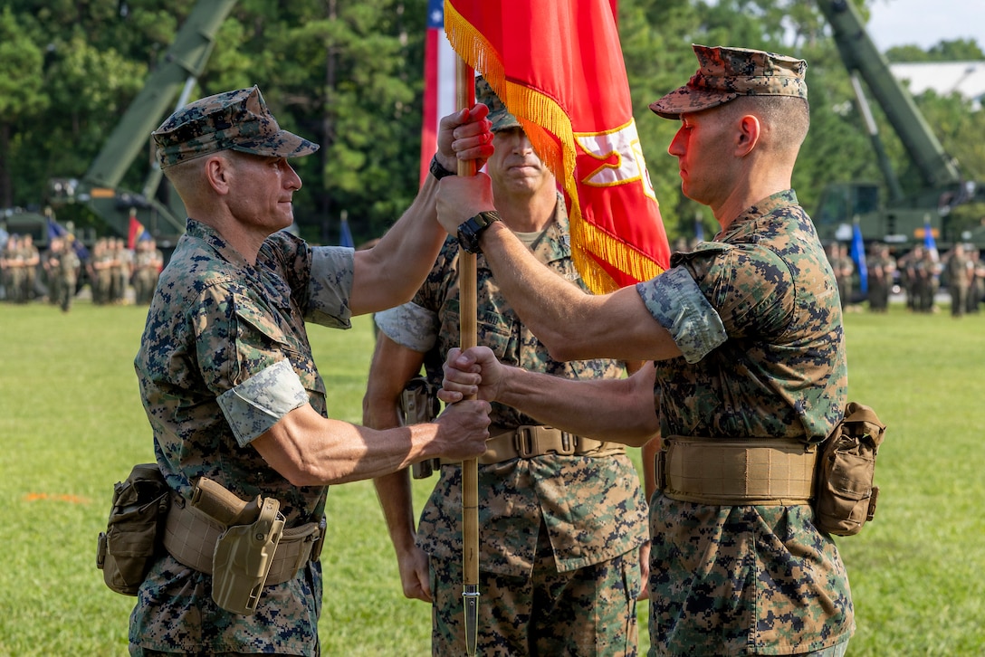 U.S. Marine Corps Col. Joseph M. Garaux, right, the outgoing commanding officer of Combat Logistics Regiment 2, 2nd Marine Logistics Group, passes the regimental colors to Col. Brett A. Bohne, the incoming commanding officer of CLR-2, 2nd MLG, during a change of command ceremony at Marine Corps Base Camp Lejeune, North Carolina, August 14, 2026. The change of command ceremony signified the transfer of command and the total accountability, authority and responsibility from Garaux to Bohne. Garaux is a native of Ohio. Bohne is a native of Texas. (U.S. Marine Corps photo by Lance Cpl. Isabella Ramos)