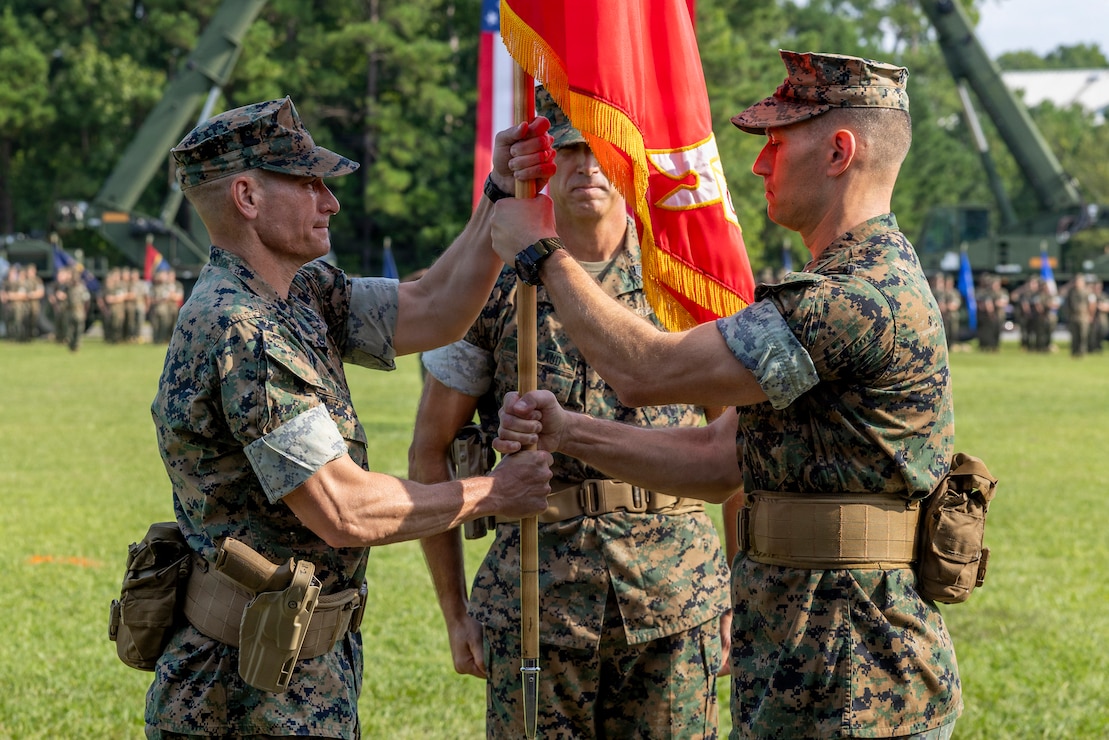 U.S. Marine Corps Col. Joseph M. Garaux, right, the outgoing commanding officer of Combat Logistics Regiment 2, 2nd Marine Logistics Group, passes the regimental colors to Col. Brett A. Bohne, the incoming commanding officer of CLR-2, 2nd MLG, during a change of command ceremony at Marine Corps Base Camp Lejeune, North Carolina, August 14, 2026. The change of command ceremony signified the transfer of command and the total accountability, authority and responsibility from Garaux to Bohne. Garaux is a native of Ohio. Bohne is a native of Texas. (U.S. Marine Corps photo by Lance Cpl. Isabella Ramos)