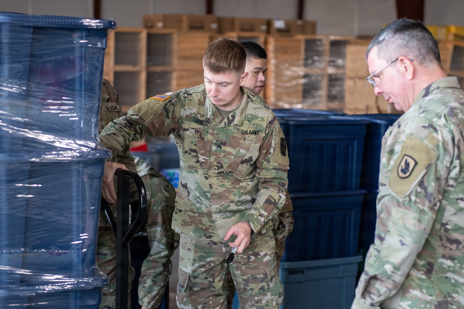 Washington Army National Guard Sgt. Keegan Tarbell, assigned to the 341st Military Intelligence Battalion, moves storage containers while helping prepare emergency relief packages during the Spokane-area wildfire response in Spokane, Wash., Aug. 11.