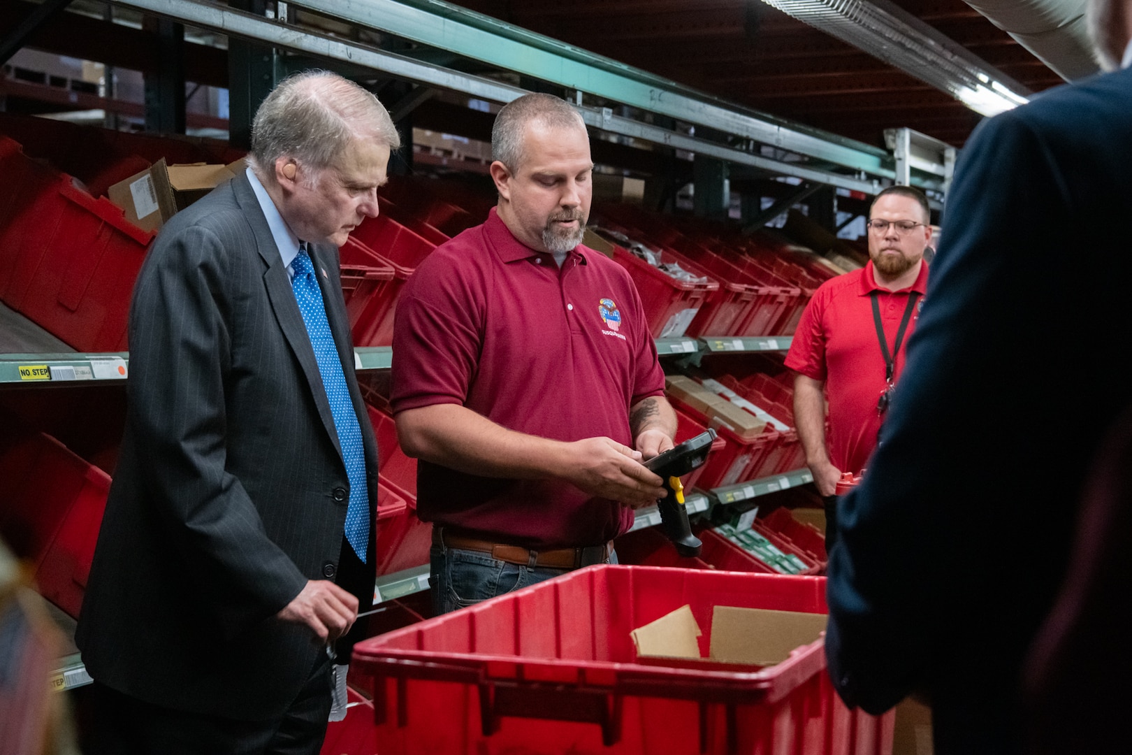 Two people seeing a demonstration of the pack house in a warehouse.