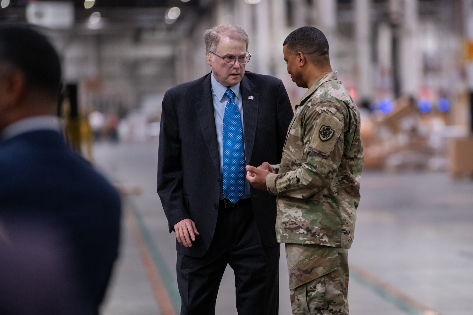 Two people talking in a warehouse.