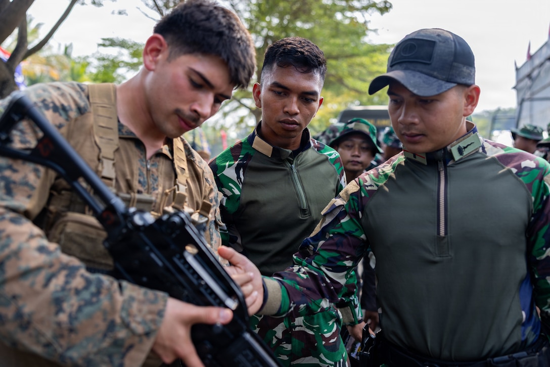 U.S. Marine Corps Lance Cpl. Eric Cardona, a rifleman with Alpha Company, 1st Battalion, 5th Marine Regiment, Marine Rotational Force – Darwin 26, speaks to Indonesian marines with 7th Infantry Battalion, 4th Brigade, on the capabilities of an M203 40 mm grenade launcher as part of a platoon exchange at the Indonesian Marine Corps 9th Battalion base near Lampung, Indonesia, Aug. 14, 2026.