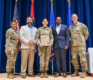 U.S. Air Force Tech. Sgt. Andrea Reyes, center, an instructor with the Chief Master Sgt. Paul H. Lankford Enlisted Professional Military Education Center, I.G. Brown Training and Education Center (TEC), poses with the GEICO Military Service Award alongside TEC leadership and members of the GEICO Military Affairs Team at McGhee Tyson Air National Guard Base, Tennessee, June 15, 2026. Reyes was selected from nominees representing the Army National Guard and Air National Guard across the country for her contributions to Airmen, her unit, and her community. (U.S. Air National Guard photo by Master Sgt. Regina Young)