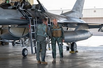 Gen. Gregory Guillot, commander of North American Aerospace Defense Command (NORAD) and U.S. Northern Command (USNORTHCOM), right, coins U.S. Air Force Col. Thomas Obrochta, 162nd Operations Group commander, after a flight in an F-16 Fighting Falcon during a visit at Eielson Air Force Base, Alaska, Aug. 13, 2026. Guillot visited the Alaskan NORAD region to observe joint operations and reinforce the strategic partnership between the United States and the Kingdom of Denmark in securing the Arctic region. (U.S. Air Force photo by Senior Airman Nicholas Paczkowski)