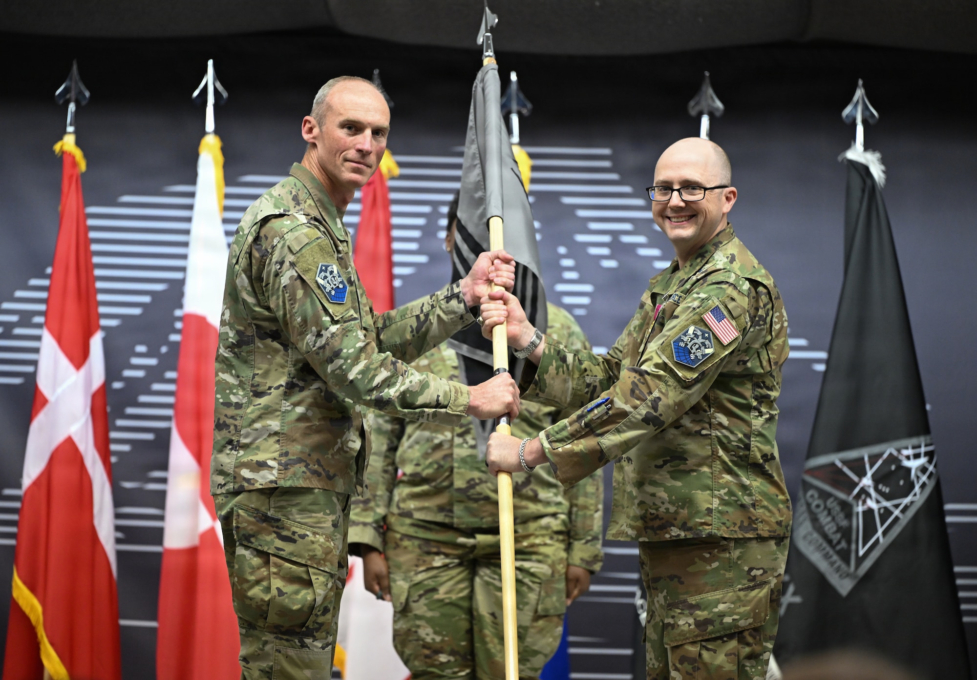 Col. Charles Cooper receives the 821st SBG guidon from Col. Shawn Lee.