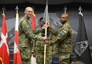 Col. Charles Cooper presents the 821st SBG guidon to Col. Keith Morris.