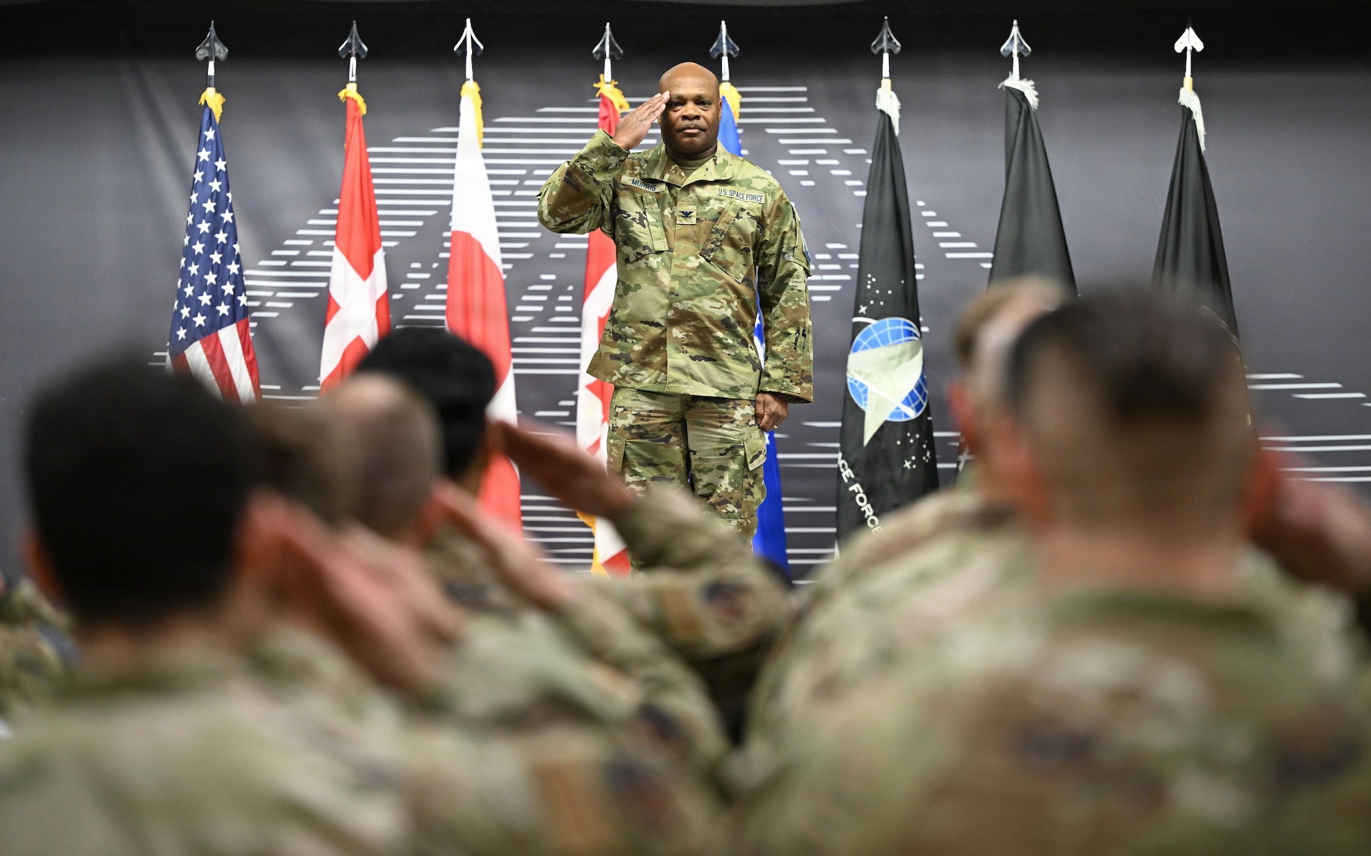 Col. Keith Morris renders a salute to service members in formation.
