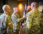 COL Jason Marquart, commander of Irwin Army Community Hospital, returns the Soldier Recovery Unit colors to 1SG Bud Morgan during the SRU’s inactivation ceremony at Fort Riley, Kansas, Aug. 14, 2026. The traditional passing of the colors, which moved from CSM Ryan Johnson to SRU Commander LTC Benjamin Peffer, and finally to COL Marquart, symbolizes the formal relinquishment of command. This exchange honors the chain of command and signifies the culmination of the unit's nearly two-decade mission before the colors are permanently cased.