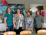The Minneapolis MEPS FRG hosts a tropical potluck. L to R: Deb Vangel, mission support specialist, Tamie Runningen, test coordinator and FRG lead, Jai Hudson, processing technician and Thone Yang, test control officer.