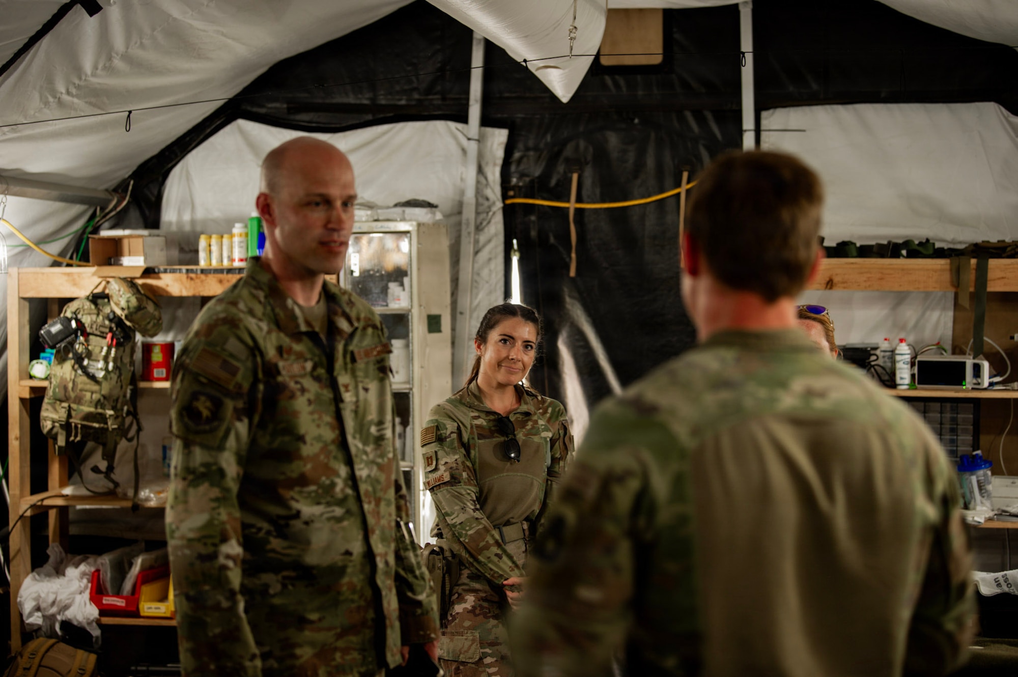 U.S. Air Force Col. Andrew Saylor, 449th Air Expeditionary Group commander, left, and U.S. Air Force Capt. Miranda Williams, 475th Expeditionary Air Base Squadron Medical Flight critical care nurse, center, listen to a brief from U.S. Army Spc. Christopher Sigman, 475th EABS Medical Flight combat medic, right, during an immersion with the 475th EABS at Manda Bay, Kenya, August 8, 2026. The 475th EABS delivers agile airbase support that enables air operations, force protection and mission sustainment throughout the region. (U.S. Army photo by Sgt. Jake Anico)