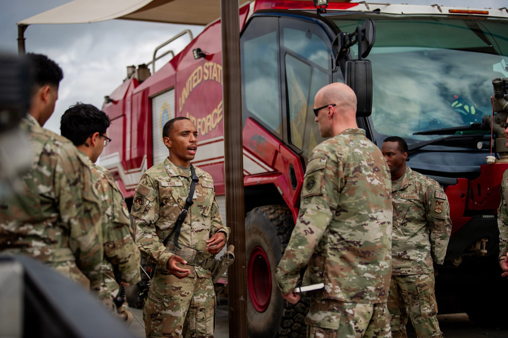 U.S. Air Force Col. Andrew Saylor, 449th Air Expeditionary Group commander, right, listens to a brief from U.S. Air Force Airman 1st Class Simeon Knox, 475th Expeditionary Air Base Squadron Civil Engineer Flight firefighter, left, during an immersion with the 475th EABS at Manda Bay, Kenya, August 8, 2026. The 475th EABS delivers agile airbase support that enables air operations, force protection and mission sustainment throughout the region. (U.S. Army photo by Sgt. Jacob Anico)
