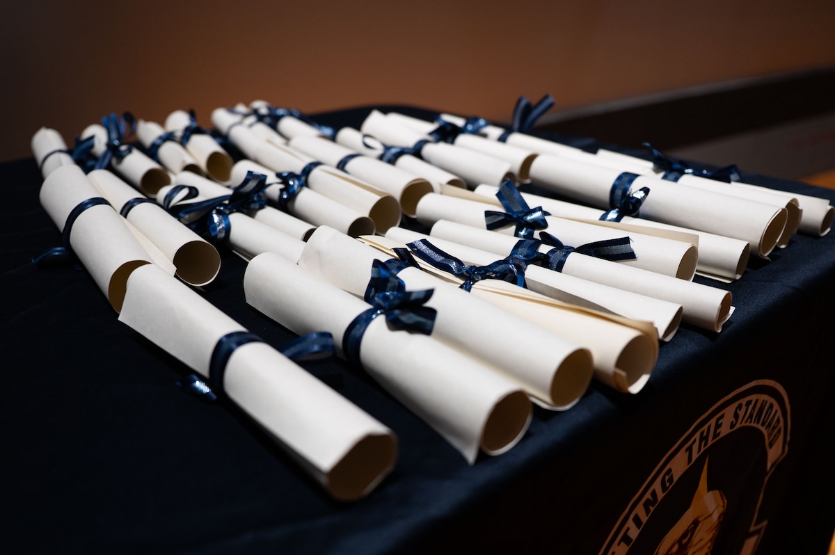 Community College of the Air Force diplomas lay on a table before a graduation ceremony at Goodfellow Air Force Base, Texas, July 31, 2026.