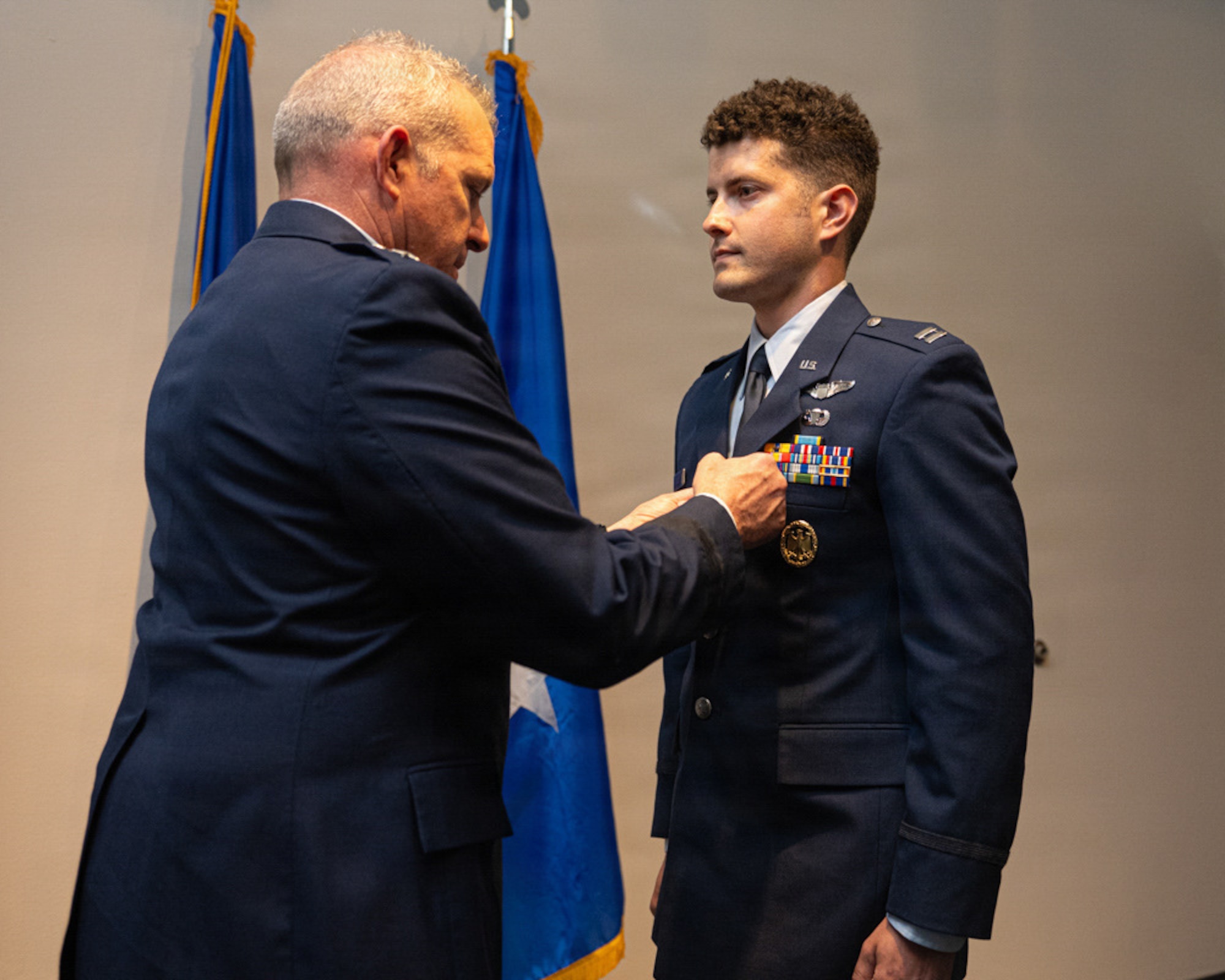 Gen. pins an award on a Captains uniform.