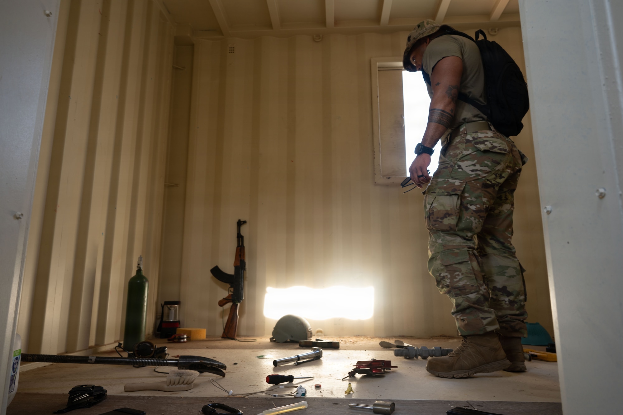 A U.S. Air Force Master Sergeant select assesses a room during a communication relay exercise at Davis-Monthan Air Force Base, Arizona, Aug. 5, 2026. Retrieval team members were given 30 seconds to memorize objects in a room and were to return to their planning team outside the building to formulate a response plan based on the intelligence given. (U.S. Air Force photo by Airman Najzee Kuzu)