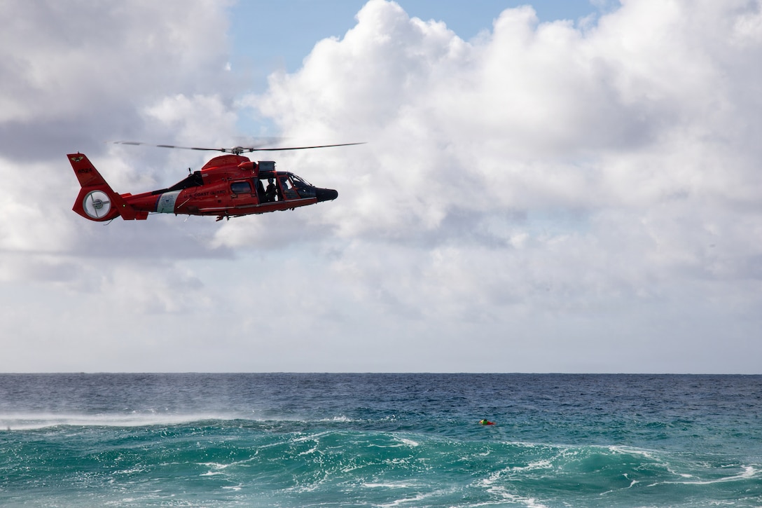 U.S. Coast Guardsmen with Coast Guard Air Station Barbers Point pilot a Eurocopter MH-65 Dolphin into position to prepare for a water safety demonstration during the Ocean Festival at Marine Corps Base Hawaii, July 17, 2026. The festival offered a vibrant blend of hands-on activities, informative displays, and live water safety demonstrations to raise awareness and reduce the inherent risks associated with summer water activities. (U.S. Marine Corps photo by Lance Cpl. Nicholas Figueroa)