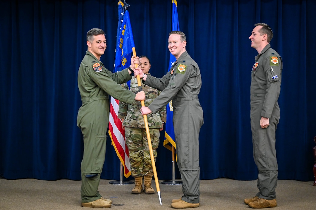 U.S. Air Force Col. Matthew Wilson, 56th Operations Group commander, passes the guidon to Lt. Col. Christopher Tegtmeyer, incoming 56th Operations Support Squadron commander, at Luke Air Force Base, Arizona, Aug. 14, 2026.