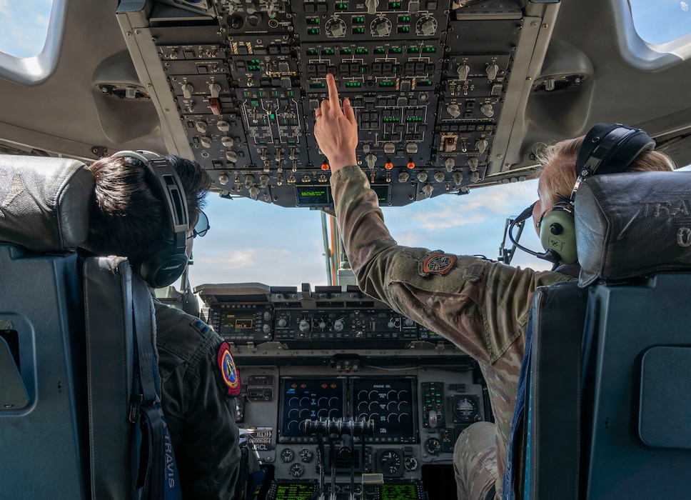Two pilots starring up at the overhead panel.