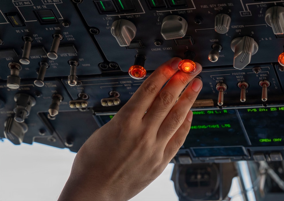 a persons finger touching a glowing red button.