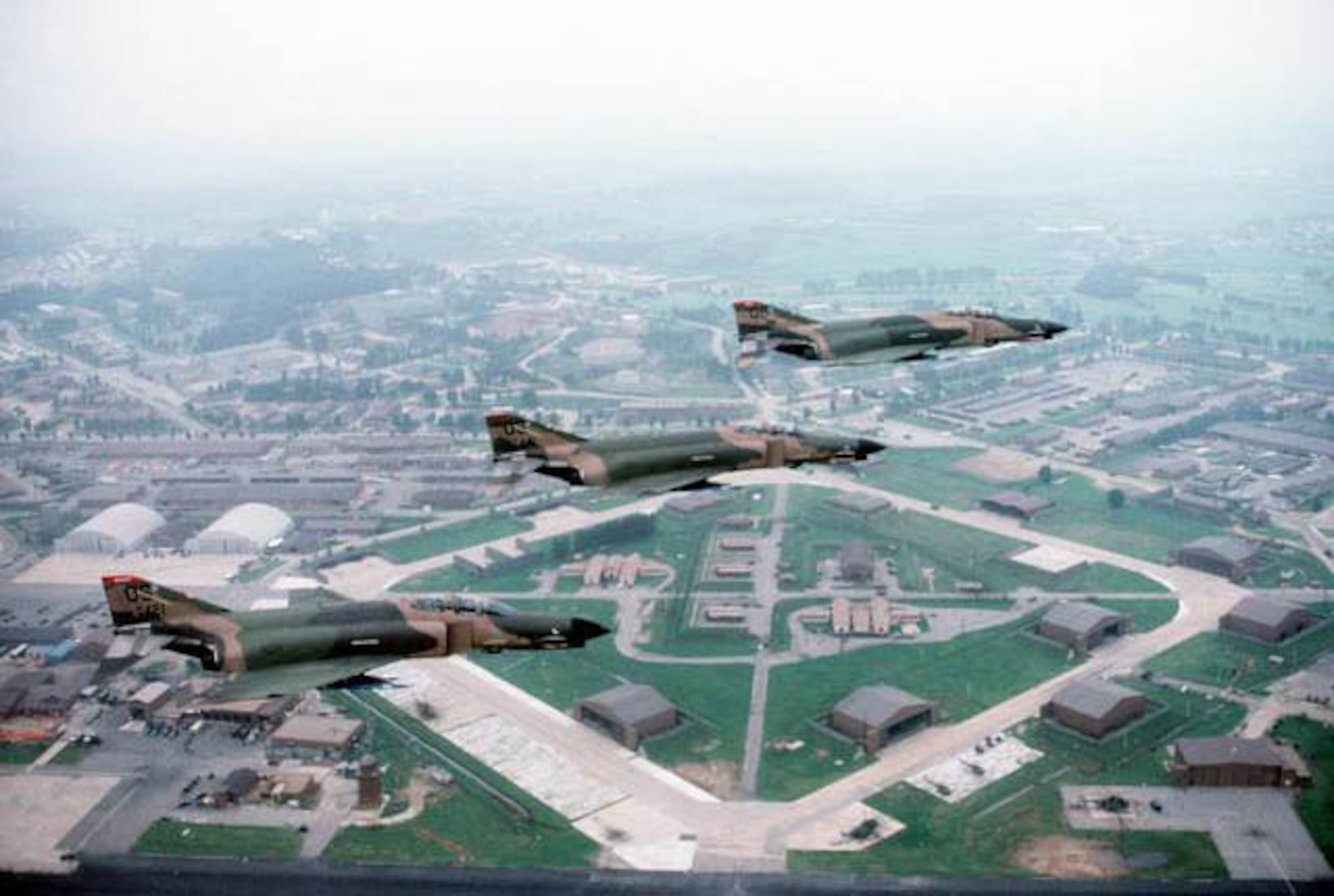 Three McDonnell Douglas F-4E Phantom IIs from the 36th Tactical Fighter Squadron "Fiends" fly in tight formation over Osan Air Base, South Korea, in 1984.