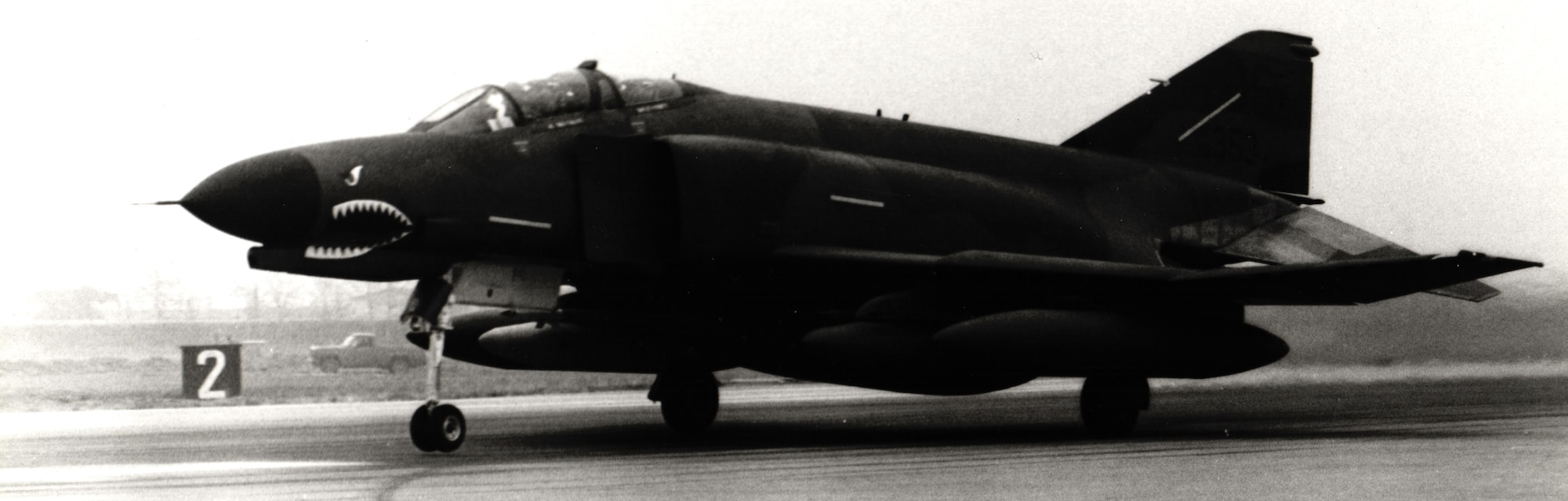 A shark-mouthed F-4E Phantom II assigned to the 51st Tactical Fighter Wing taxis down the runway at Clark Air Base, Philippines, in May 1986 during Exercise Cope Thunder.