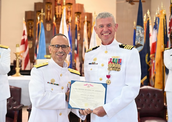 Rear Adm. Robert Hawkins (left), commander Naval Medical Forces Atlantic and director of Defense Health Network Atlantic, presents Capt. Craig Malloy (right), outgoing commander of Navy Medicine Readiness and Training Command Jacksonville and director of Naval Hospital Jacksonville, the Legion of Merit Award during a change of command ceremony at Naval Air Station Jacksonville All Saints Chapel, Florida, Aug. 13. The award recognized his leadership in strengthening clinical readiness, developing Sailors, improving access to care and advancing partnerships that supported the command's readiness mission.  (U.S. Navy photo by Julie M. Lucas, Naval Hospital Jacksonville Public Affairs/released).