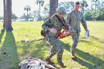 Hospital Corpsman 1st Class Austin Peevey, instructs Hospitalman Sara Hoffer, both assigned to Navy Medicine Readiness and Training Command Pensacola, during a Tactical Combat Casualty Care (TCCC) Final Exercise at Naval Hospital Pensacola, Pensacola, Florida, April 17, 2026. Peevey was recognized for his TCCC efforts during Operation Enduring Freedom and for the his ability of being a TCCC instructor.  (U.S. Navy photo by Mass Communication Specialist Seaman Jon Jezreel Andres)