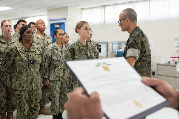 U.S. Navy Rear Adm. Guido Valdez, medical officer of the Marine Corps, presents a Navy and Marine Corps Achievement Medal to U.S. Navy Hospital Corpsman 3rd Class Hailey Arp during a visit to Naval Branch Health Clinic Marine Corps Recruit Depot San Diego, Aug. 14. NBHC MCRDSD is a branch of Naval Medical Center San Diego. NMCSD employs more than 5,500 active-duty military personnel, civilians, and contractors in southern California to deliver exceptional care afloat and ashore. (U.S. Marine Corps photo by Lance Cpl. Janell B. Valerio Alvarez)