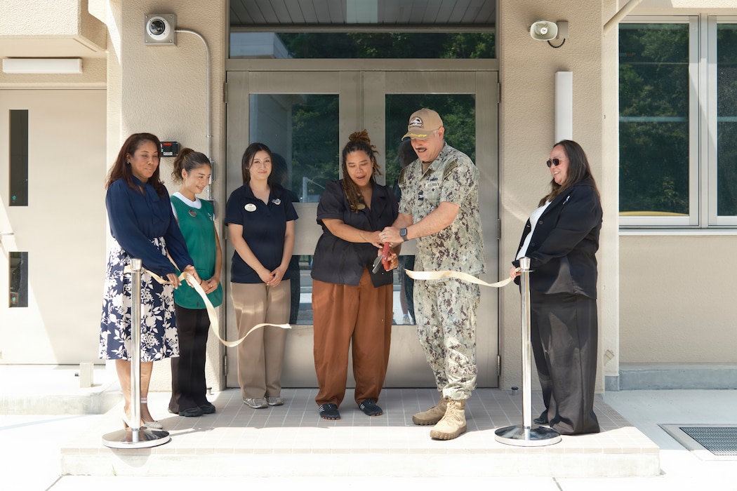 IKEGO HILLS FAMILY HOUSING AREA, Japan (August 10, 2026) -- Capt. Jonathan Hopkins, Commander, Fleet Activities Yokosuka, and Trischa Sanders, Commander, Fleet Activities Yokosuka Child and Youth Programs (CFAY CYP) Ikego Youth Programs, cut a ceremonial ribbon outside the Ikego Youth Programs building Monday, August 10, 2026.  The two-floor, nearly 23,000 square foot facility began construction in July 2023 and offers a School Age Care Center, Teen Center, tween program, indoor basketball court, several multipurpose rooms, a kitchen, music room, laundry facilities, and staff offices to serve military-connected youth of varying ages in Ikego Hills. (U.S. Navy photo by James Kimber)