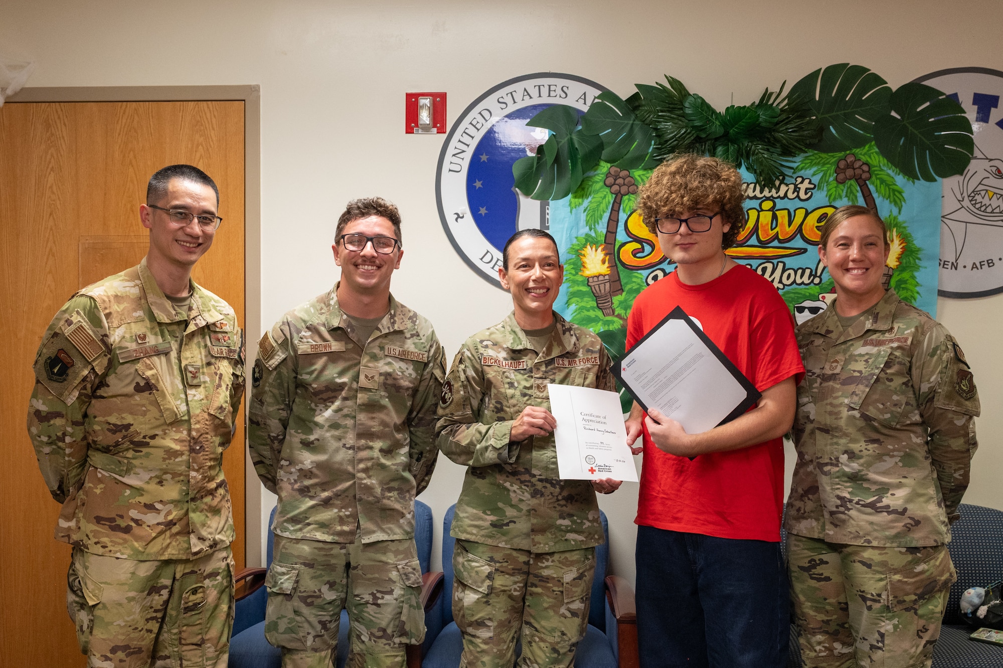 Members of the 36th Medical Group present a certificate of appreciation to American Red Cross VolunTEEN Richard Henry Caballero during the program’s closing ceremony at Andersen Air Force Base, Guam, Aug. 13, 2026. The summer program provided military-connected youth opportunities to gain professional experience while supporting daily operations throughout the military treatment facility. (U.S. Air Force photo by Airman 1st Class Charline Ebreo)